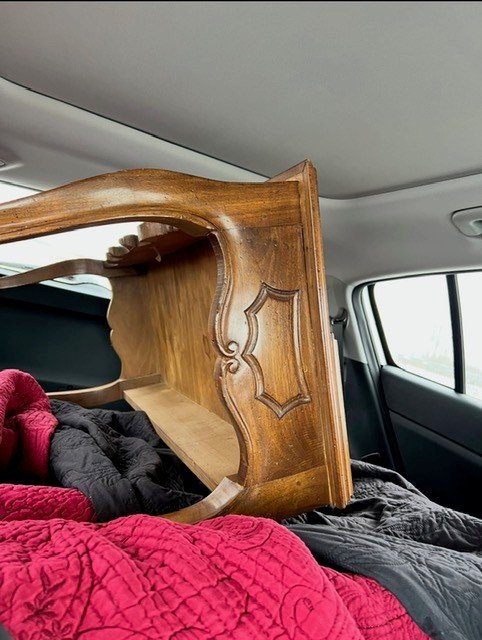Hutch in the vehicle: Vintage wood hutch loaded in the back of an SUV after purchase.