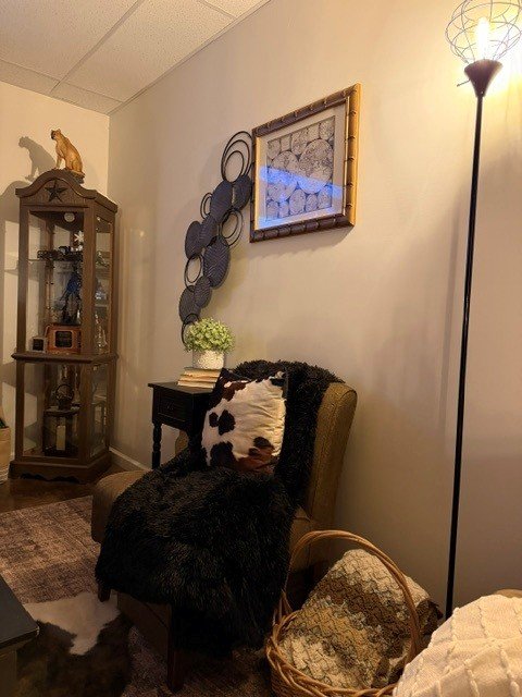 Basement rec room with white walls, blackened bronze accent wall, and warm lighting.